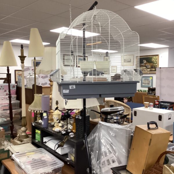 Vintage metal birdcage on stand, decorative avian habitat.