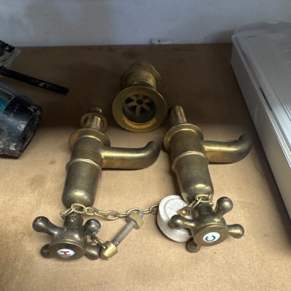 Vintage brass basin taps and waste fitting for antique bathroom restoration.