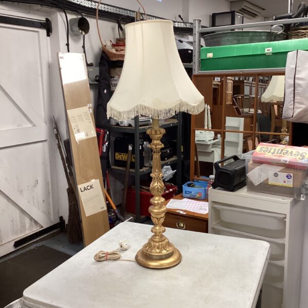 Ornate vintage brass table lamp with fringed shade.