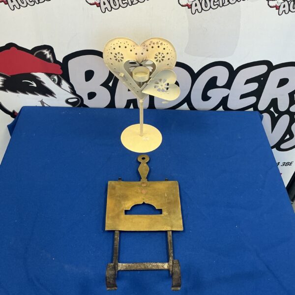 Vintage brass trivet with heart-shaped candle holder for fireplace decor.