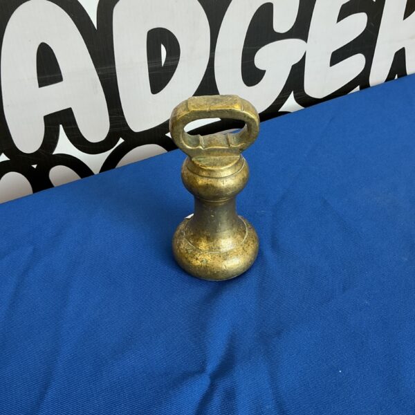 Vintage brass weight for antique scales, a collectible item.