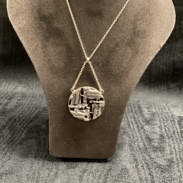 Vintage Brutalist silver pendant on display.
