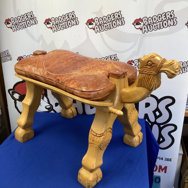 Vintage camel footstool with worn leather cushion, unique home decor.