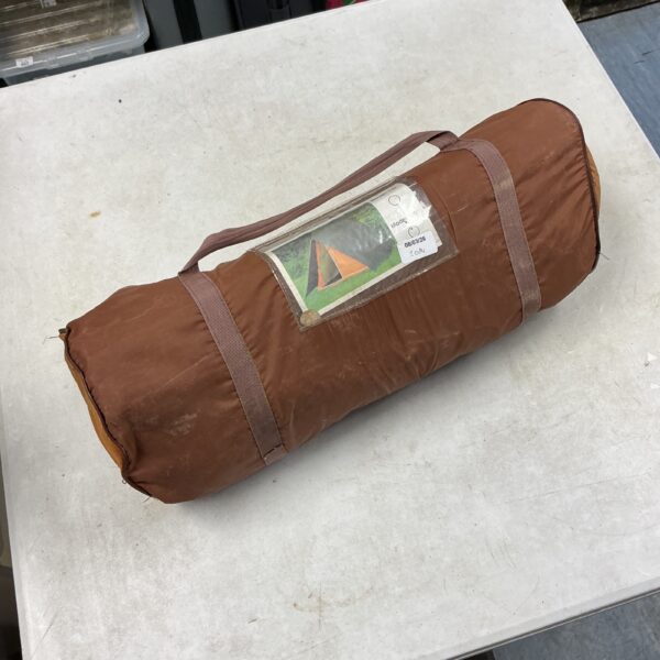 Rolled vintage canvas tent, showing wear and age.
