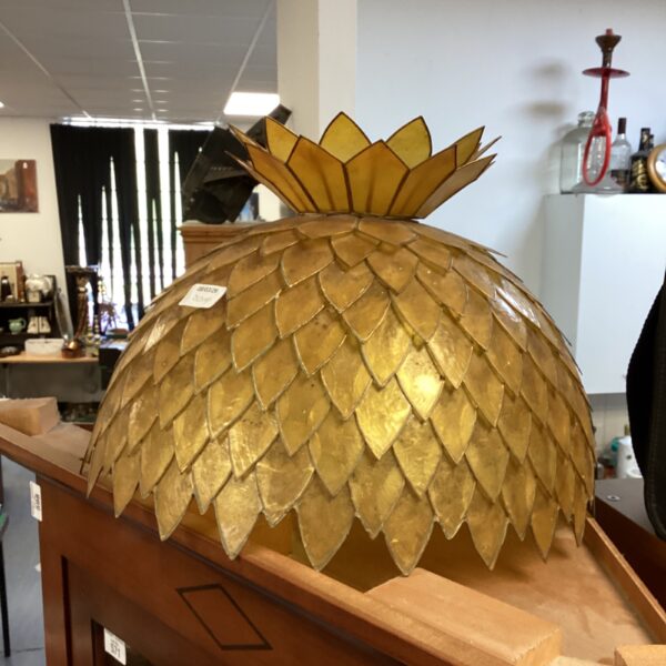 Golden vintage celluloid lamp shade with scale-like texture.