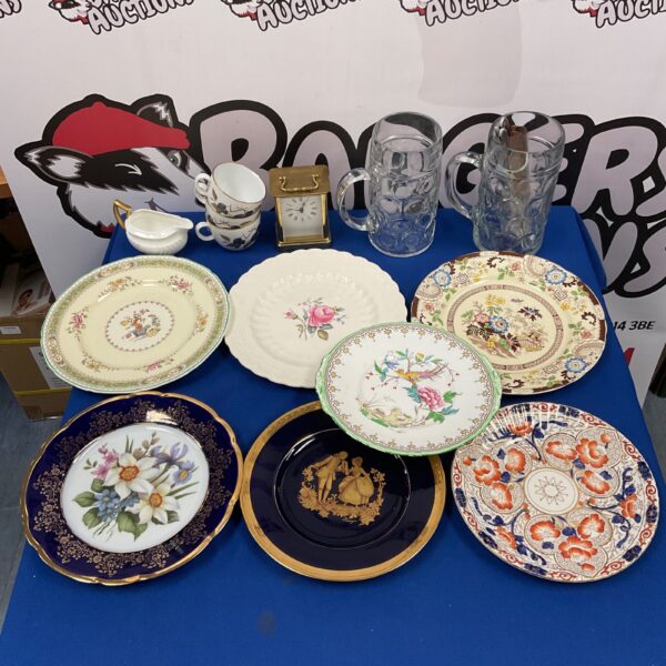 Vintage china collection featuring decorative plates and ornate tankards.