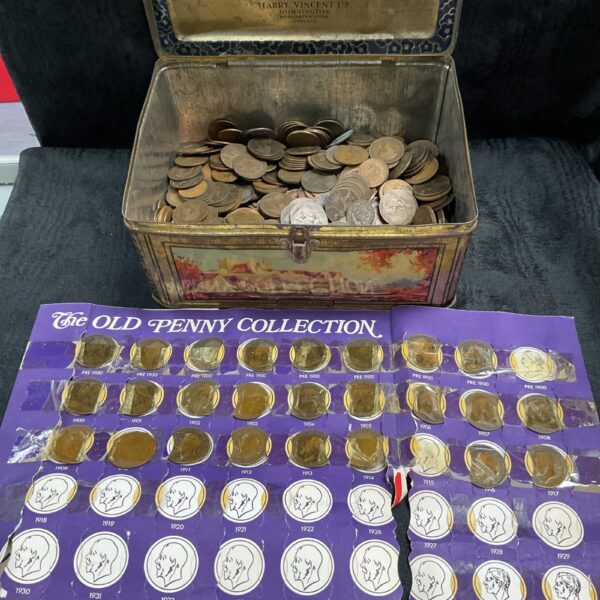 Large collection of vintage copper pennies in a metal container.
