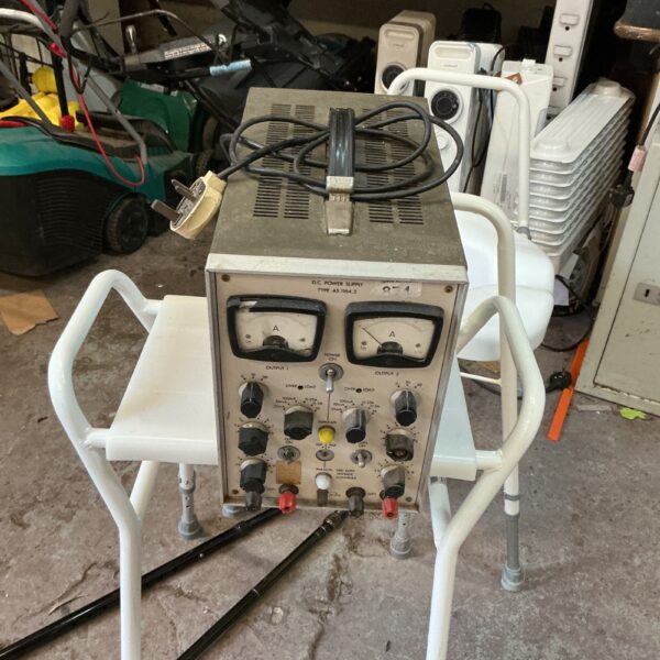Vintage DC power supply with analog meter and output terminals.