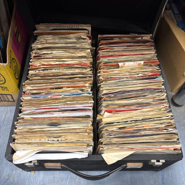 Vintage DJ case filled with a large collection of 7 inch vinyl records.