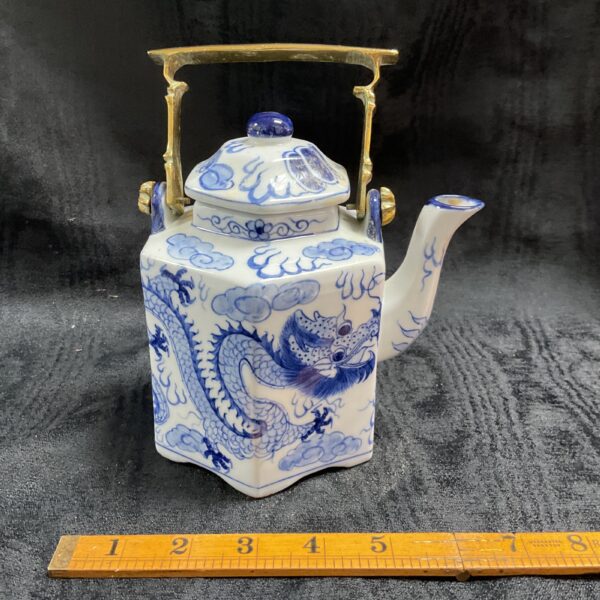 Vintage blue and white dragon teapot with brass handle.