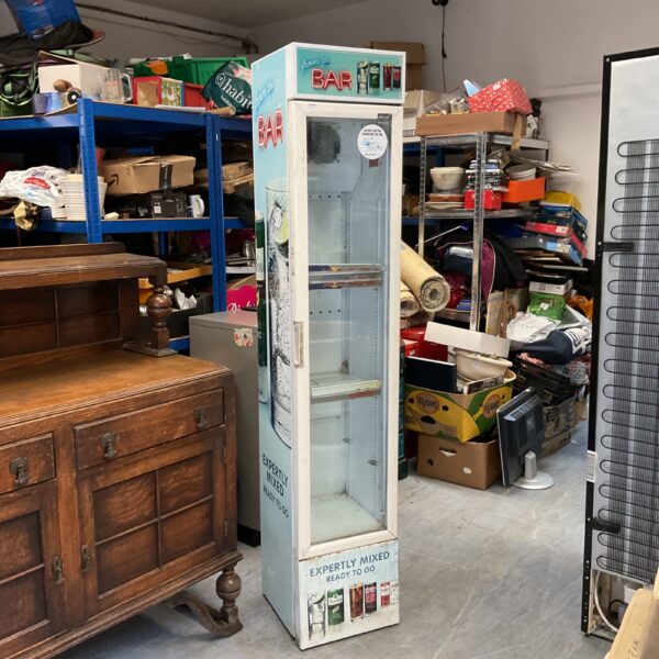 Vintage drinks fridge in a shop setting, ideal for collectors.