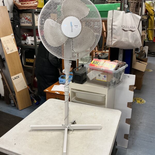 White vintage electric stand fan on a table.