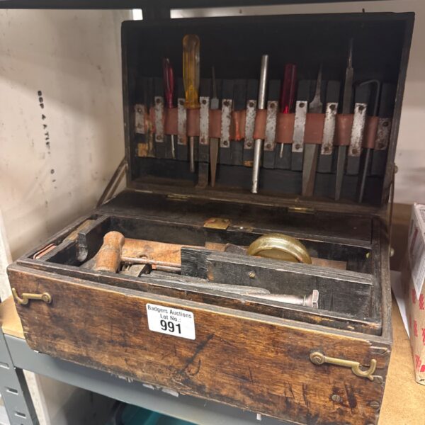 Open vintage engineer's toolbox with antique tools inside.