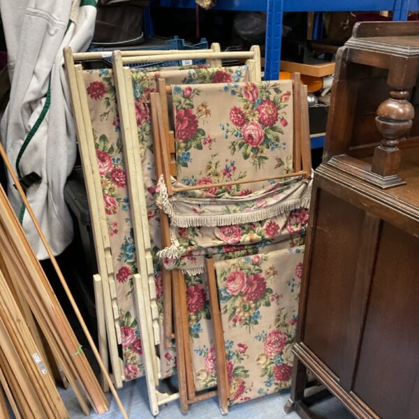 Three vintage floral deck chairs with wooden frames.
