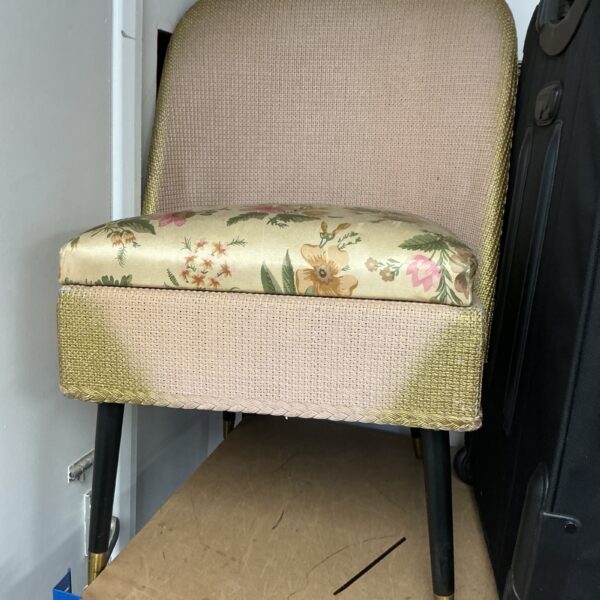 Vintage floral nursery chair with yellow upholstery and tapered legs.