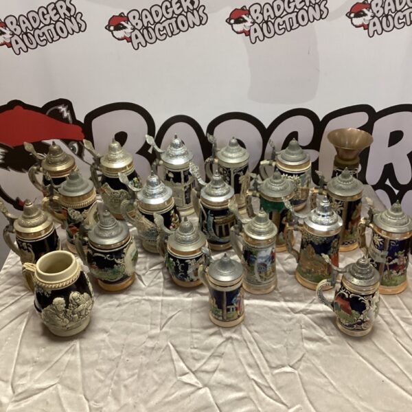 Collection of vintage German steins with detailed designs.