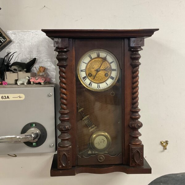 Vintage German wall clock with enamel face and dark wood case.