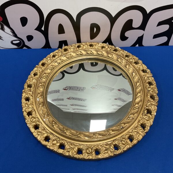 Ornate gilt framed convex mirror, vintage wall decor.