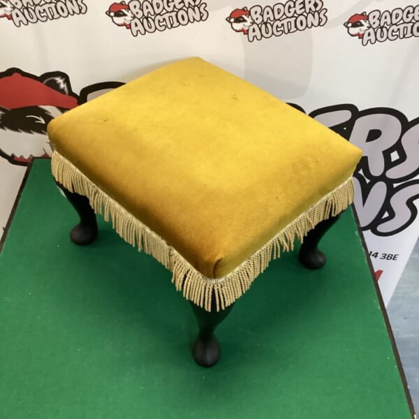 Gold upholstered vintage footstool with turned wooden legs.