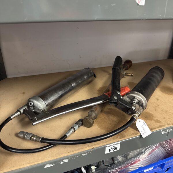 Vintage grease guns and weed sprayer, antique workshop tools.
