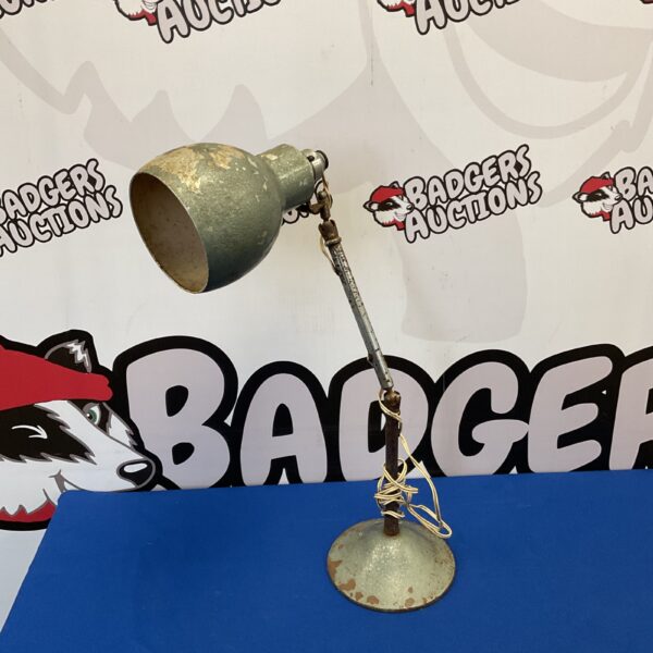 Vintage industrial lamp with adjustable arm and metal shade.