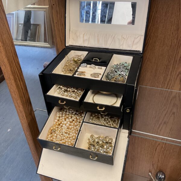 Open vintage jewellery case filled with costume jewellery.