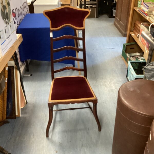 Vintage ladder back chair with upholstered seat and wooden frame.
