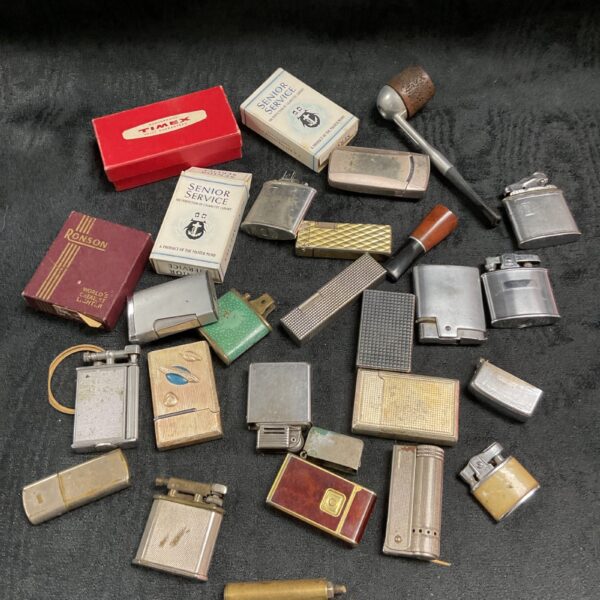 Assorted vintage lighters and smoking accessories in a collectible lot.