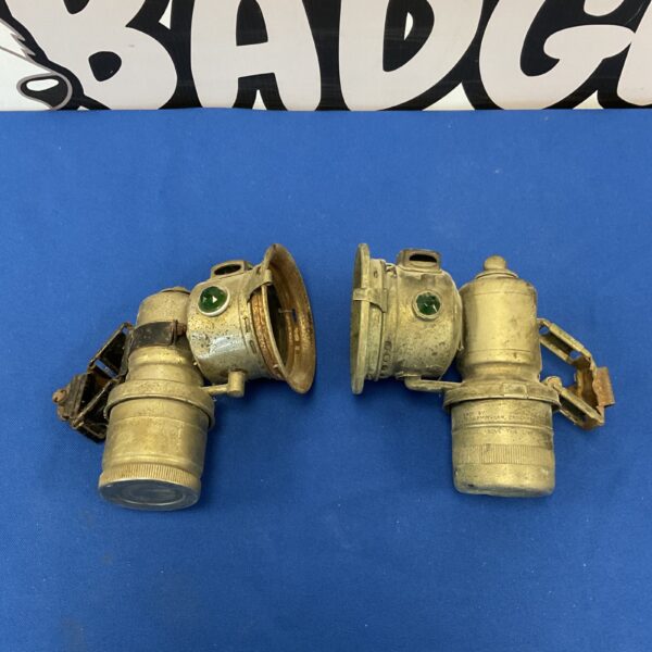 Pair of vintage Lucas bike lamps on a blue background.