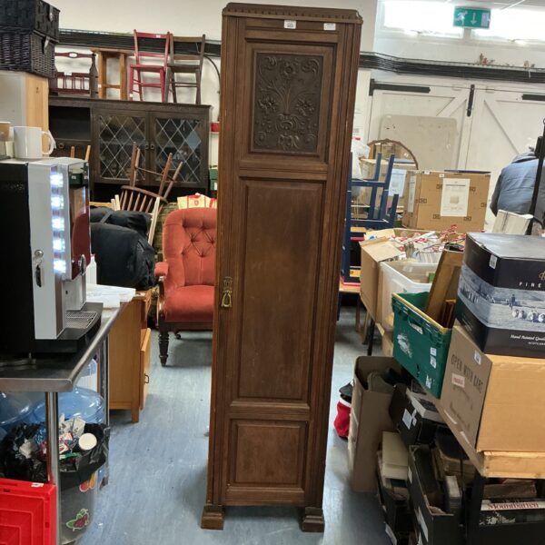 Vintage oak magician’s wardrobe in a cluttered room.