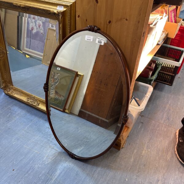 Vintage mahogany oval mirror with bevelled glass, a classic home decor piece.