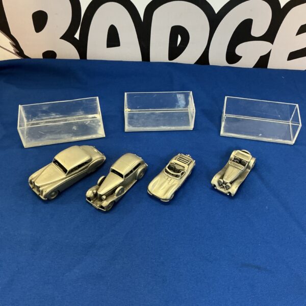 Vintage metal car ornaments displayed for collectors.