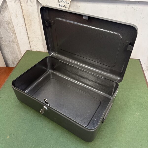 Vintage metal cash tin with key for secure storage.