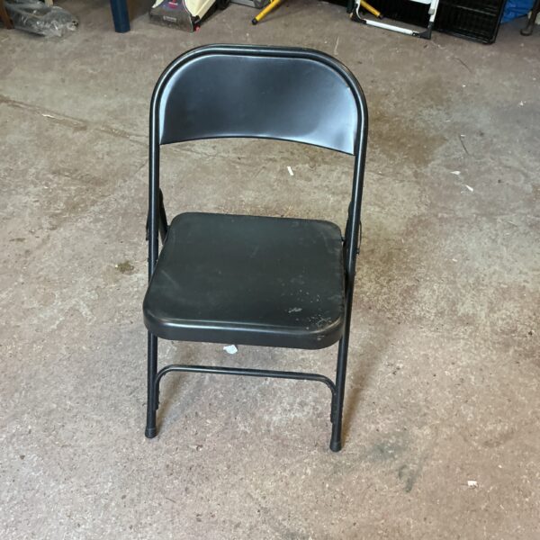 Vintage metal folding chair with signs of wear.
