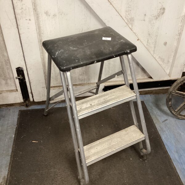 Vintage metal folding step stool for household use.