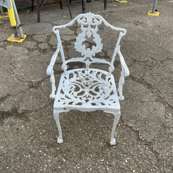 Ornate vintage metal garden chair with scrolling details.