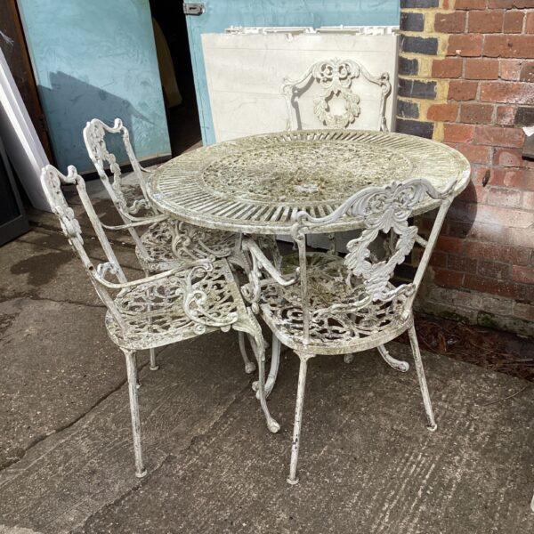 Vintage metal garden furniture set with floral detailing.