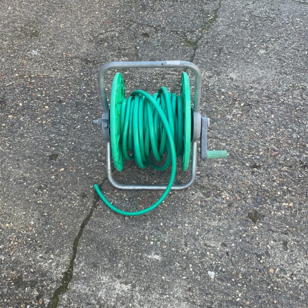 Vintage metal garden hose reel for outdoor garden hose storage.