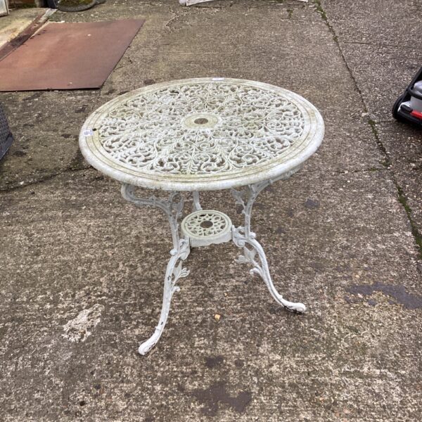 Detailed vintage metal garden table with floral design.