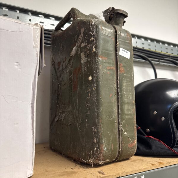 Weathered vintage metal jerry can, showing signs of age and use.