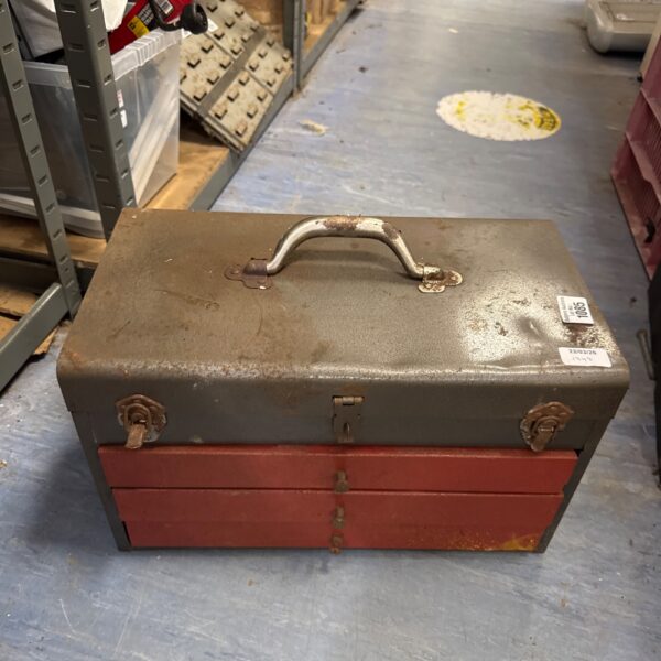 Front view of a vintage metal toolbox with a carrying handle.