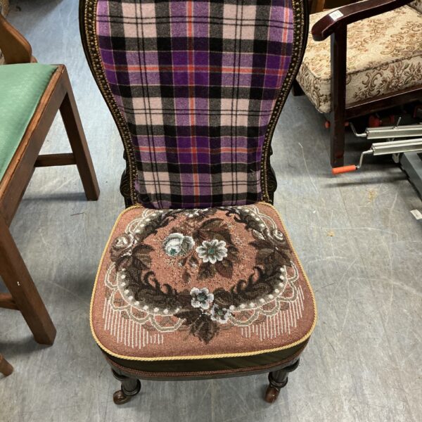 Vintage nanny chair with patterned upholstery and wooden frame.