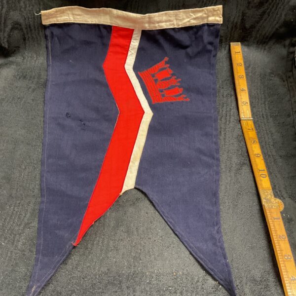 Vintage naval pennant flag with detailed crest and red stripe.