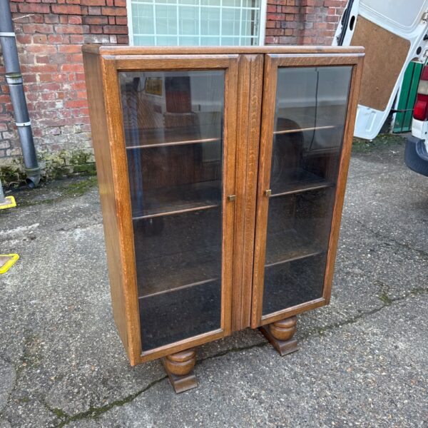 Front view of a vintage oak glass fronted shelving cabinet.