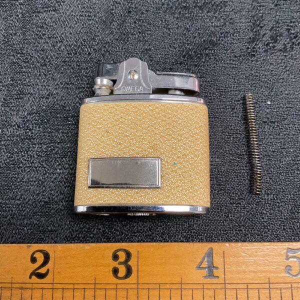 Vintage Omega petrol lighter with yellow body and chrome lever.