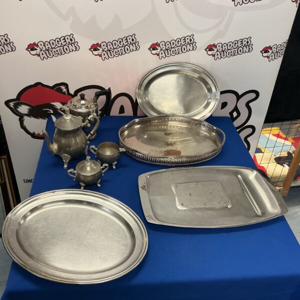 Vintage pewter coffee set with stainless steel tableware on display.