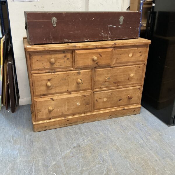Vintage pine cabinet with seven drawers for rustic storage.