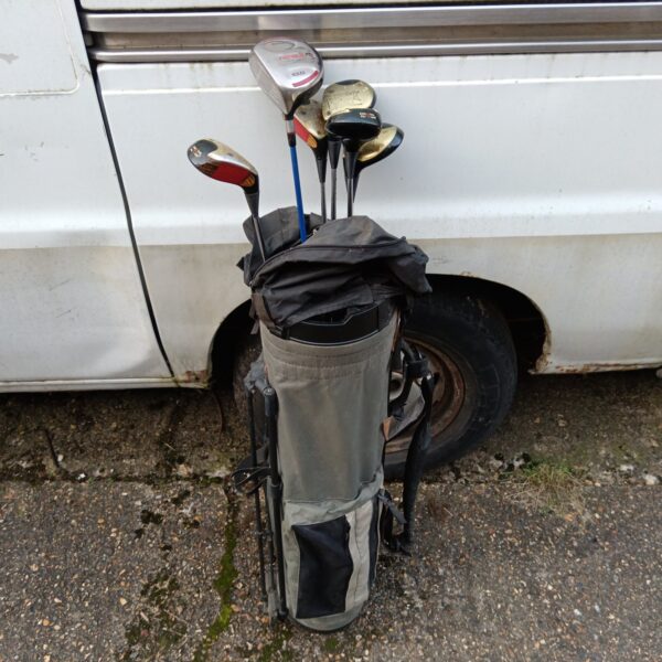 Vintage Ping golf clubs in a worn carrying bag.