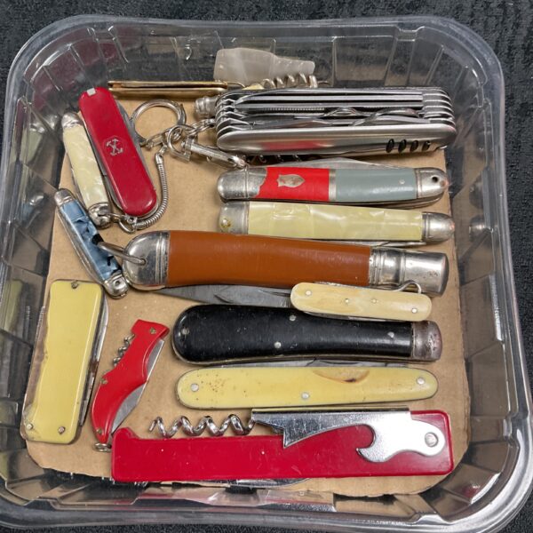 Tray of assorted vintage pocket knives, collectible folding tools.