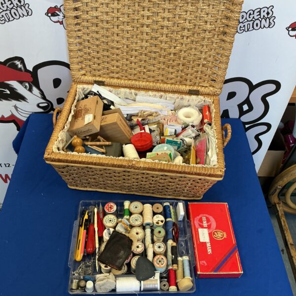 Vintage raffia sewing basket filled with colourful sewing supplies.